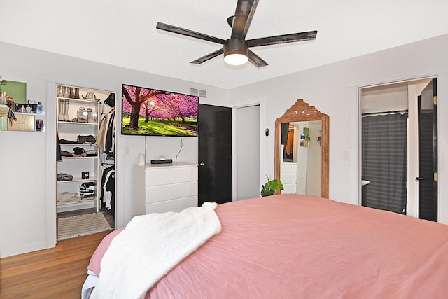 bedroom featuring ceiling fan, visible vents, wood finished floors, and ensuite bathroom