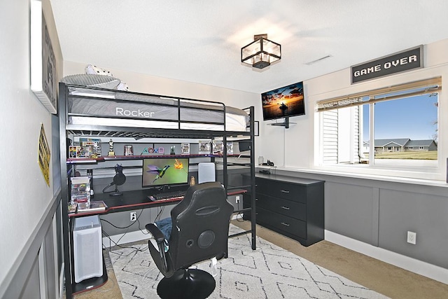 carpeted bedroom with a decorative wall