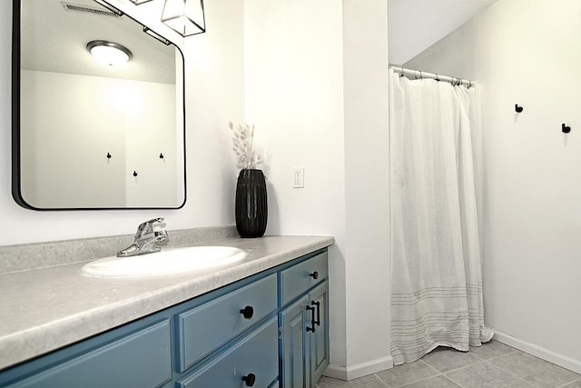 full bath featuring tile patterned flooring, baseboards, and vanity