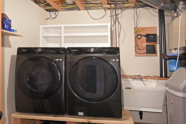 clothes washing area featuring washing machine and dryer and a sink