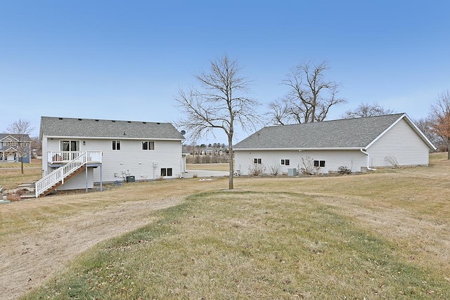 rear view of property featuring stairs, a yard, and a deck