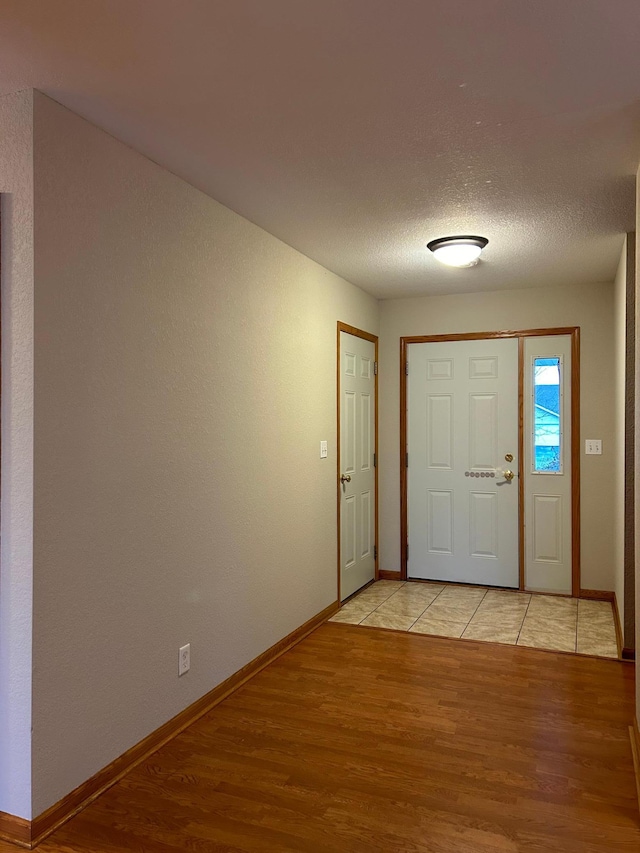 foyer featuring light wood-type flooring and a textured ceiling