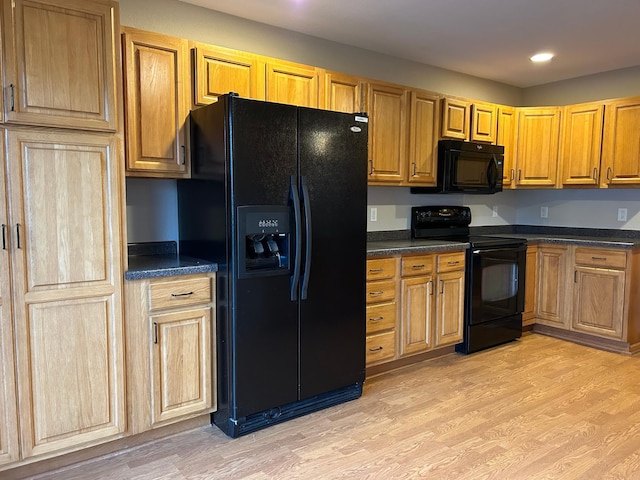 kitchen with black appliances and light hardwood / wood-style flooring