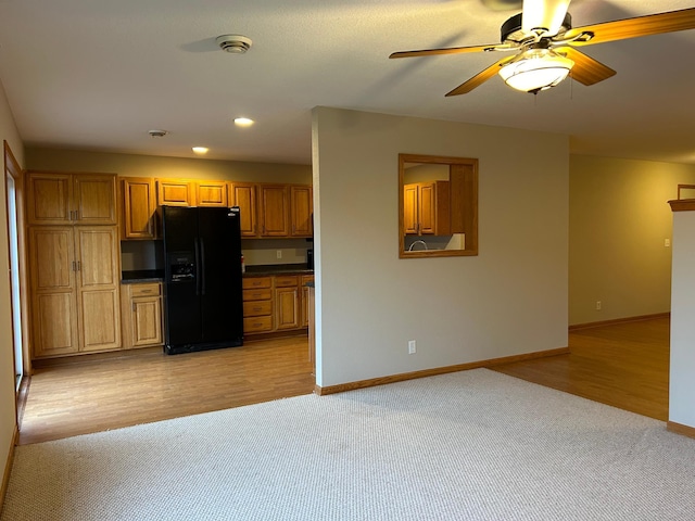 kitchen with light hardwood / wood-style floors, black refrigerator with ice dispenser, and ceiling fan