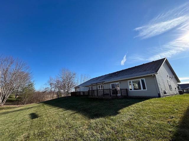 rear view of property with a yard and a wooden deck