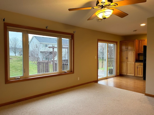 unfurnished living room featuring light carpet and ceiling fan