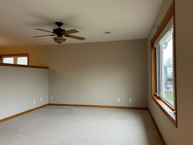 spare room featuring plenty of natural light, ceiling fan, and carpet floors