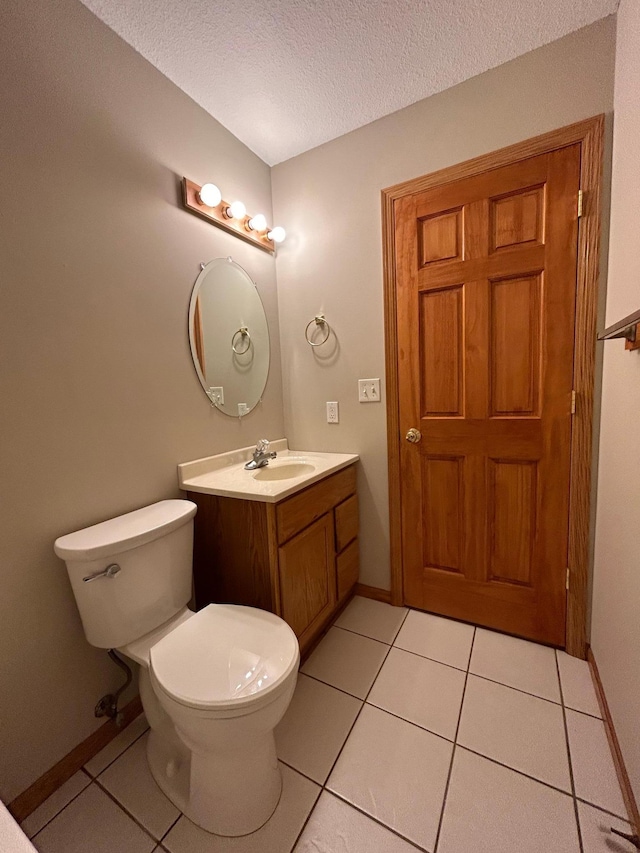 bathroom with tile patterned floors, vanity, toilet, and a textured ceiling