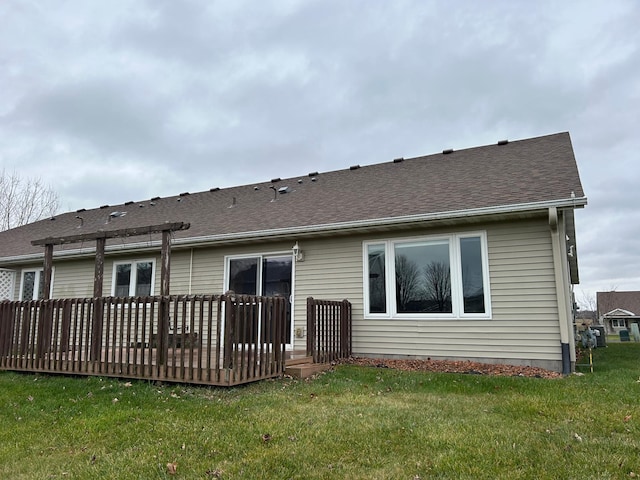 back of house with a deck and a yard