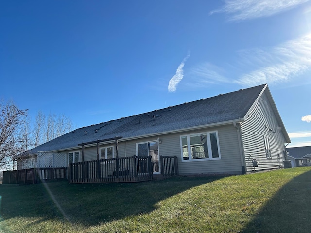 rear view of house with a deck and a lawn