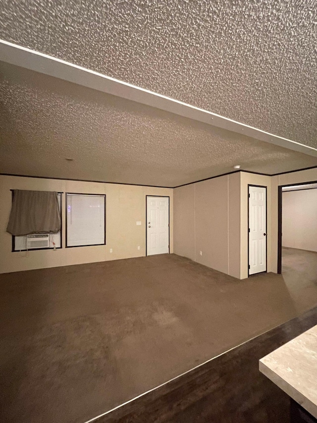 interior space featuring dark colored carpet and a textured ceiling