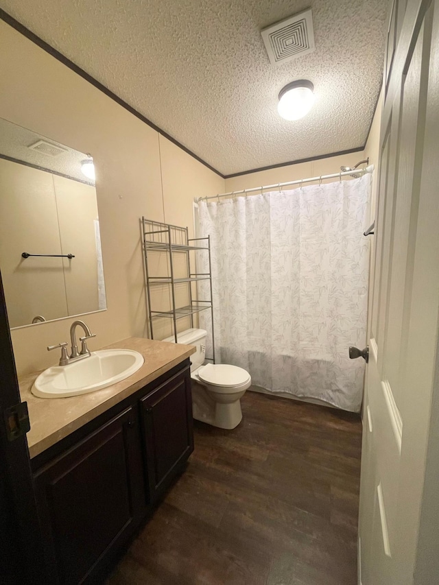 bathroom with vanity, hardwood / wood-style flooring, toilet, a textured ceiling, and walk in shower