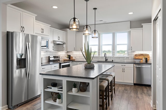 kitchen featuring dark hardwood / wood-style floors, a center island, white cabinetry, and appliances with stainless steel finishes