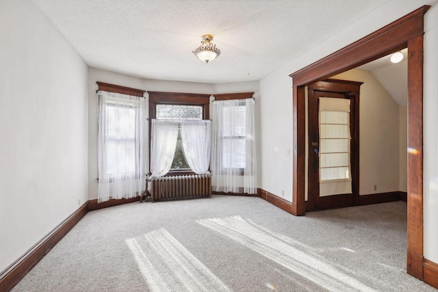 unfurnished room featuring french doors, a textured ceiling, light colored carpet, radiator heating unit, and lofted ceiling