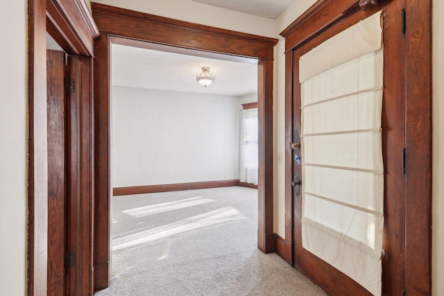 hallway featuring light colored carpet