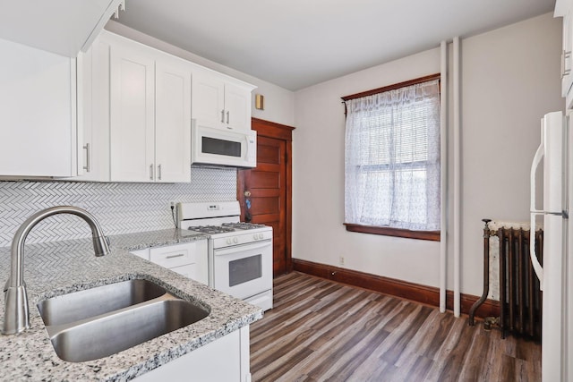 kitchen with white appliances, radiator, sink, dark hardwood / wood-style floors, and white cabinetry