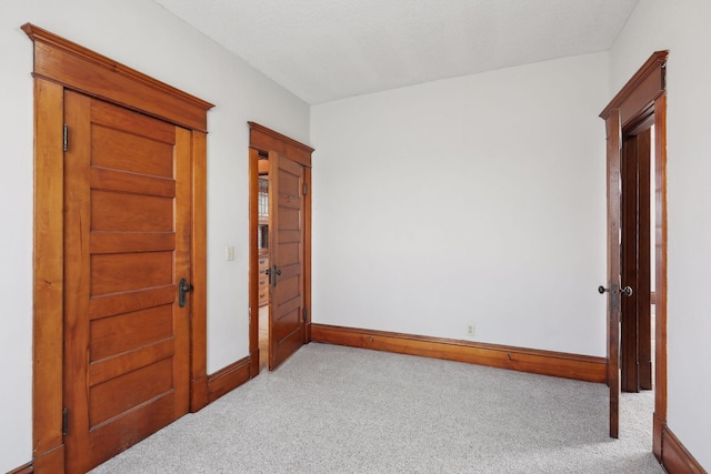 interior space featuring light carpet and a textured ceiling