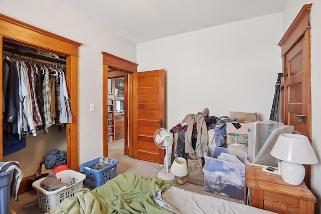 carpeted bedroom featuring a textured ceiling and a closet