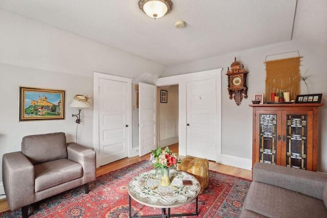 living room featuring vaulted ceiling and hardwood / wood-style flooring