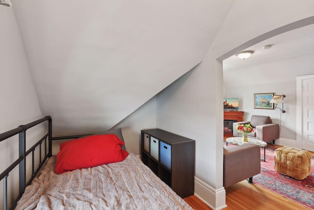 bedroom featuring light hardwood / wood-style floors and vaulted ceiling