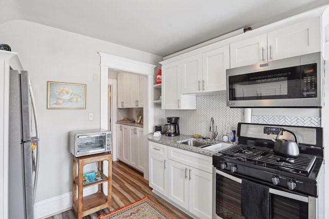 kitchen with tasteful backsplash, stainless steel appliances, dark wood-type flooring, sink, and white cabinets