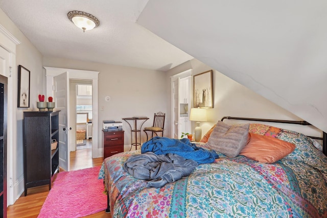 bedroom featuring a textured ceiling and light hardwood / wood-style floors