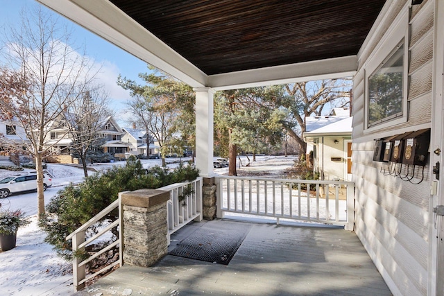 snow covered patio featuring a porch