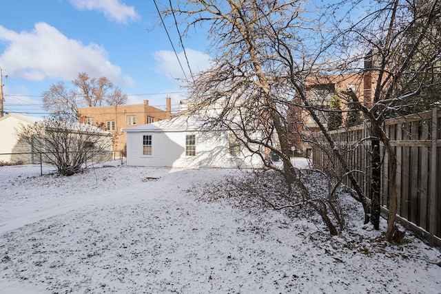 view of snow covered back of property