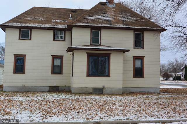 view of snow covered back of property