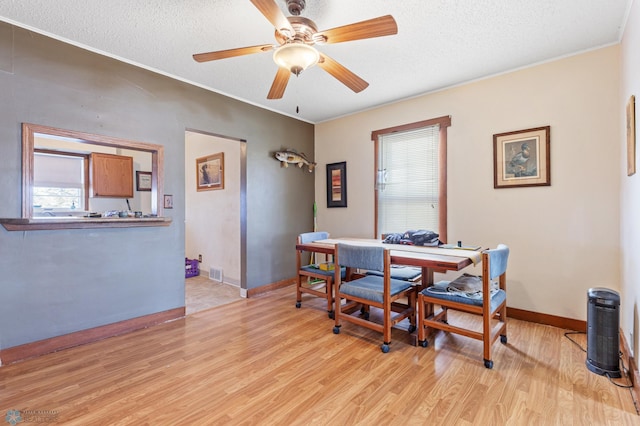 dining space featuring a textured ceiling, light hardwood / wood-style flooring, ceiling fan, and ornamental molding