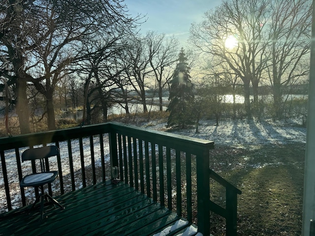 deck at dusk featuring a water view