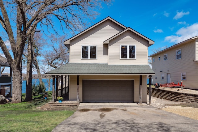 view of front of home with an attached garage, aphalt driveway, roof with shingles, and a porch