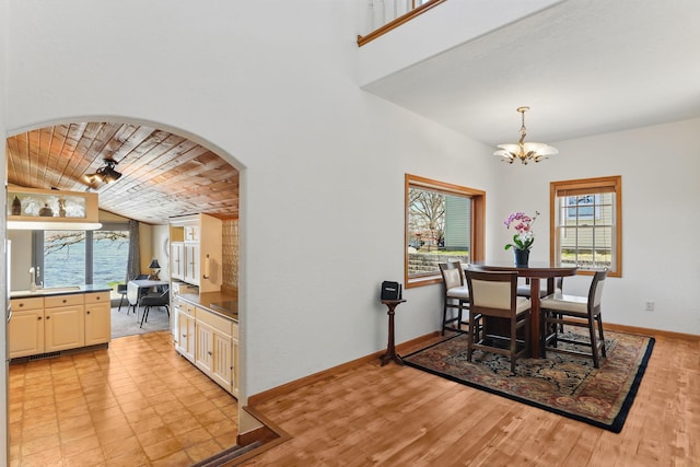 dining space featuring an inviting chandelier, wood ceiling, plenty of natural light, and baseboards