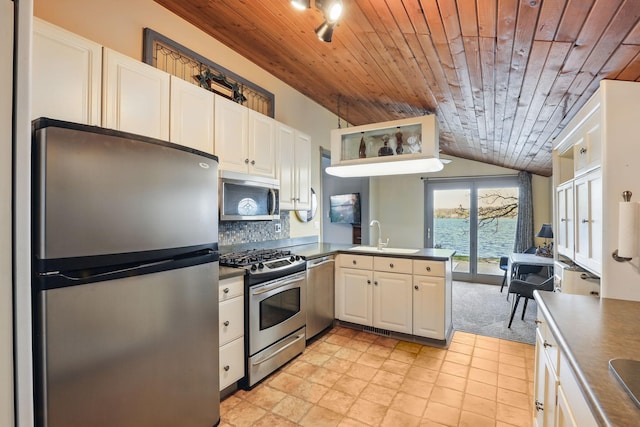 kitchen featuring a peninsula, dark countertops, wood ceiling, a sink, and stainless steel appliances
