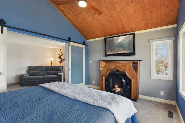 carpeted bedroom with wooden ceiling, baseboards, and a barn door