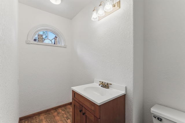 bathroom with vanity, wood finished floors, and toilet