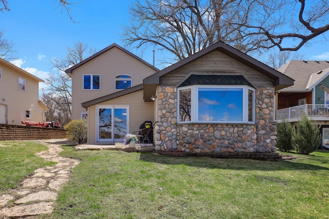 rear view of house with a yard and stone siding
