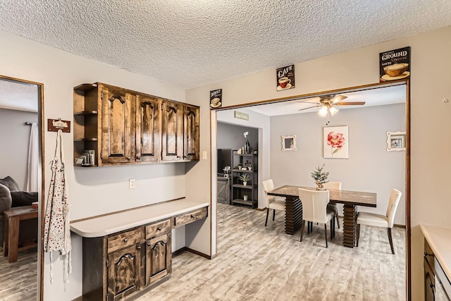 kitchen featuring ceiling fan, dark brown cabinetry, light wood-type flooring, and a textured ceiling