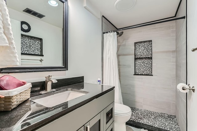 bathroom featuring vanity, toilet, and walk in shower