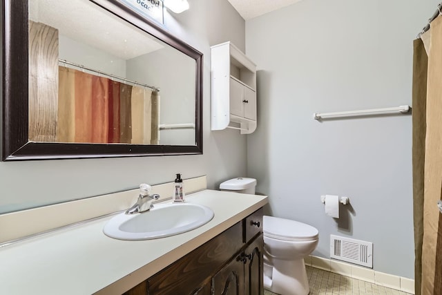 bathroom featuring tile patterned floors, vanity, and toilet