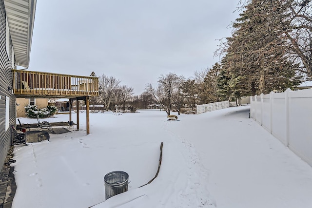 yard layered in snow featuring a deck