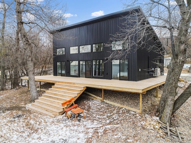 snow covered house with a wooden deck