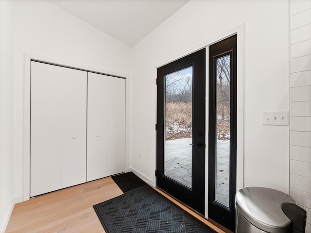 entrance foyer with light hardwood / wood-style flooring and vaulted ceiling