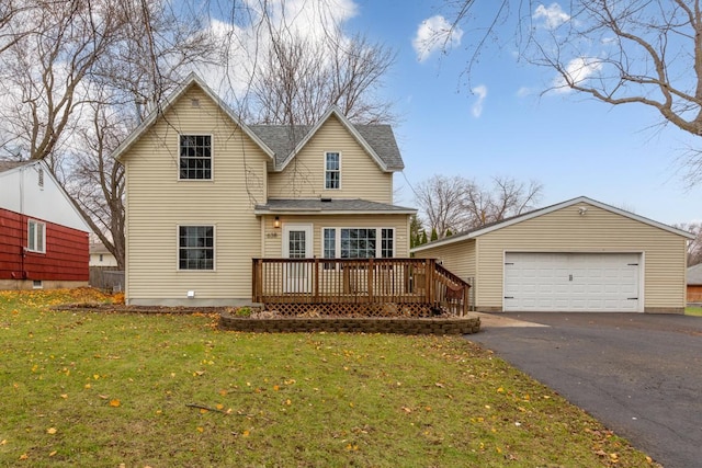 back of property with a lawn, a garage, and a wooden deck