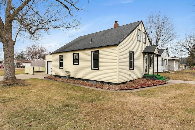 view of property exterior with an outdoor structure, a garage, and a yard