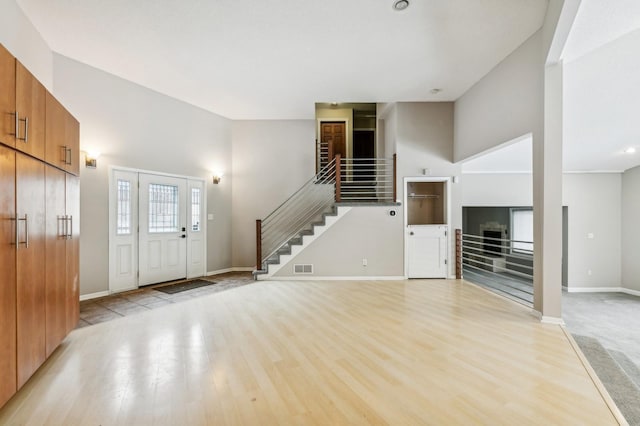 foyer entrance featuring a high ceiling and light hardwood / wood-style floors