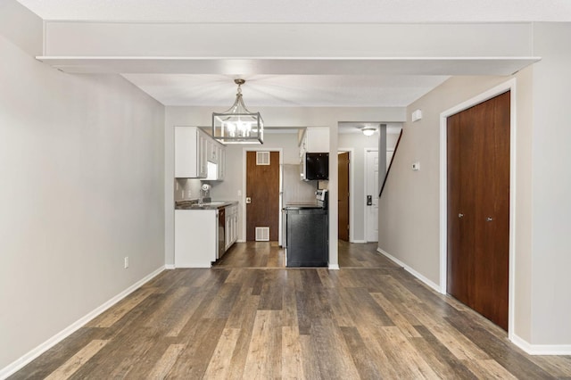 kitchen with an inviting chandelier, dark hardwood / wood-style floors, hanging light fixtures, white cabinets, and sink