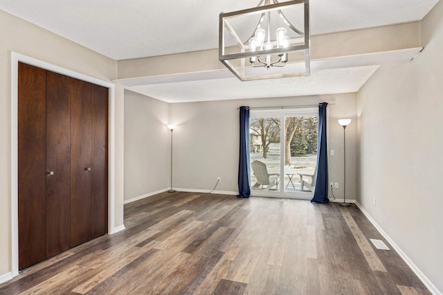 interior space featuring wood-type flooring, a chandelier, and a textured ceiling