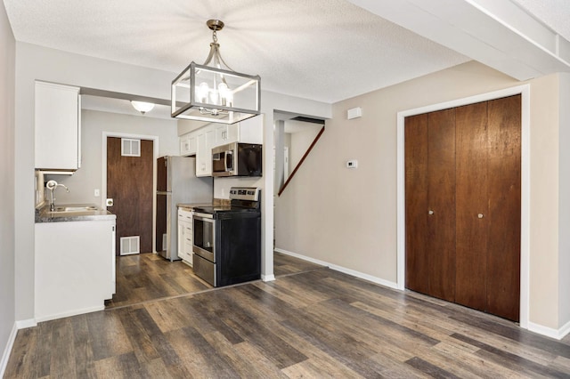 kitchen featuring appliances with stainless steel finishes, white cabinetry, dark hardwood / wood-style flooring, sink, and hanging light fixtures