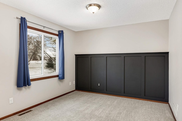 unfurnished bedroom featuring light colored carpet and a textured ceiling